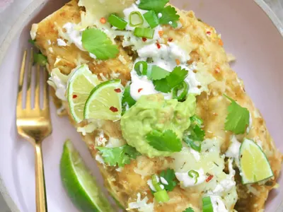 Green Chicken Enchiladas with cheddar and shredded cheese